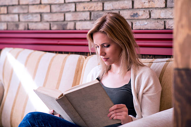 istock Blond woman with newspaper in cafe drinking coffee 538781970