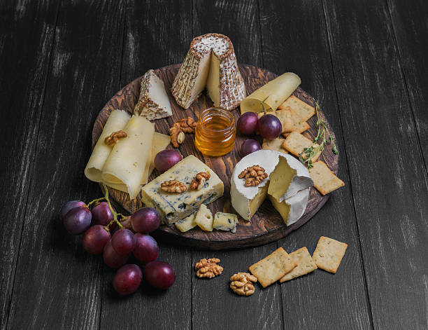 istock Assorted cheeses on round wooden board plate 538785556