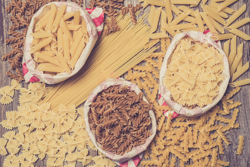 Pasta in paper bag on wooden table