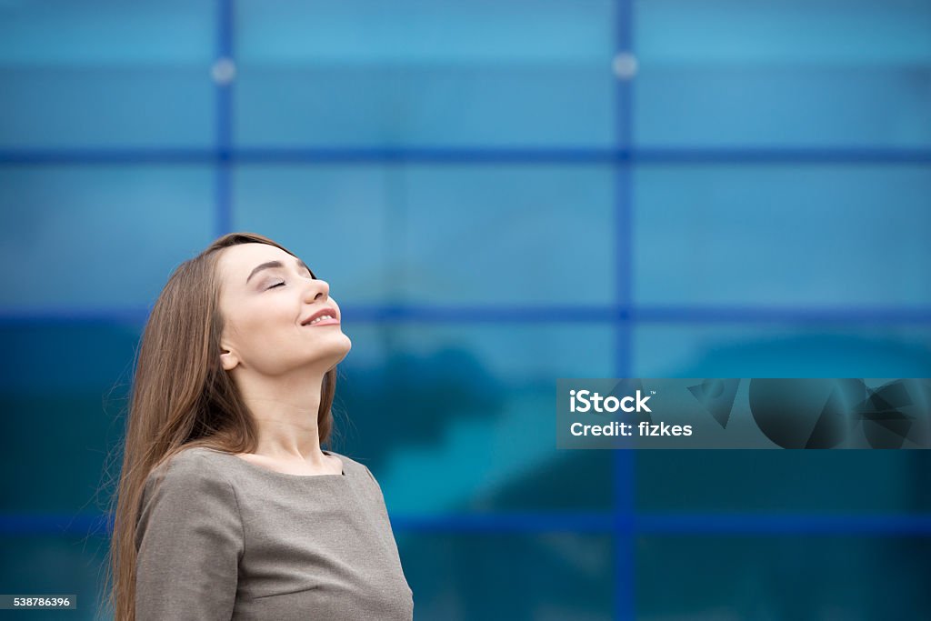 Portrait of business woman relaxing and feeling happy. Copy spac Portrait of cheerful young woman relaxing outdoors with closed eyes. Happy beautiful caucasian woman breathing fresh air on the street in summer. Copy space Wellbeing Stock Photo