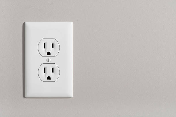 Electric Outlet A white home electrical outlet on a light grey wall. amperage stock pictures, royalty-free photos & images