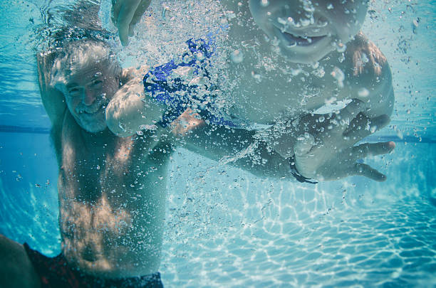 istock Grandfather teaching grandson to swim underwater 538788068