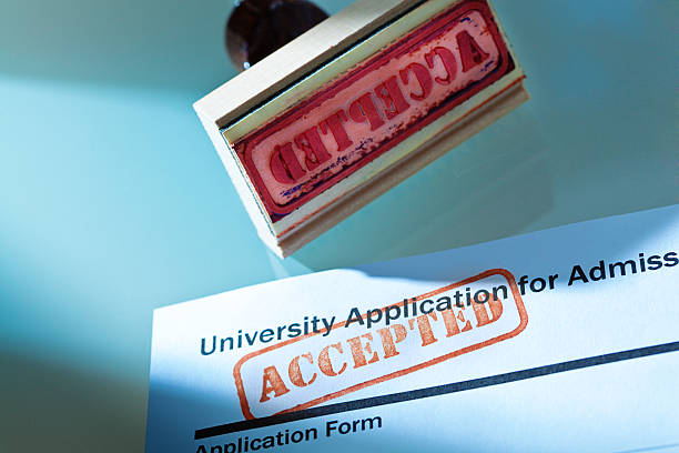 University Application Acceptance Notification Letter with ACCEPTED Stamp An acceptance letter from a university application. An university application form and the letter of acceptance with a red rubber stamp of "Accepted" on a table top still life. Photographed close-up in horizontal format with selected focus on the rubber stamp impression. college acceptance letter stock pictures, royalty-free photos & images