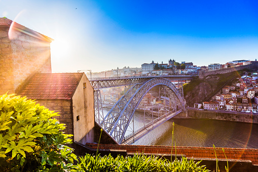 An sunset sunflare view of Douro River with the Dom Luis I bridge which is a monument and now declared a UNESCO World Heritage site. Porto is the second largest city of Portugal situated in the north of Portugal.