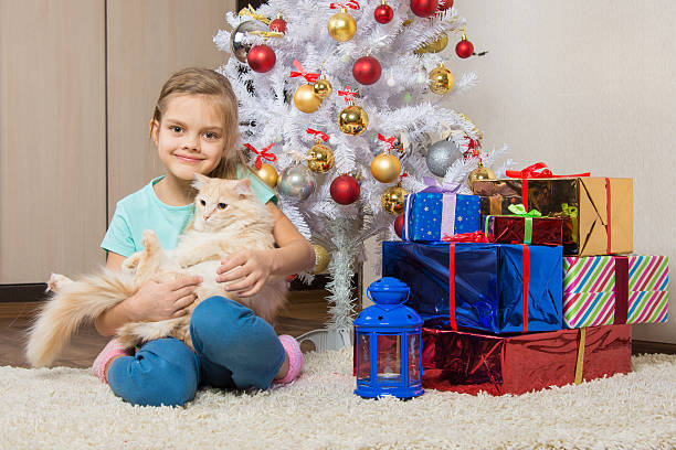 istock Joyful seven year old girl with a cat sitting under 538792352