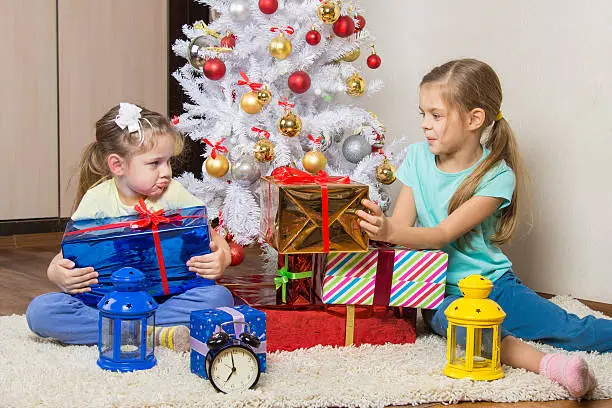 Photo of Two girls share presented New Year gifts at the Christmas