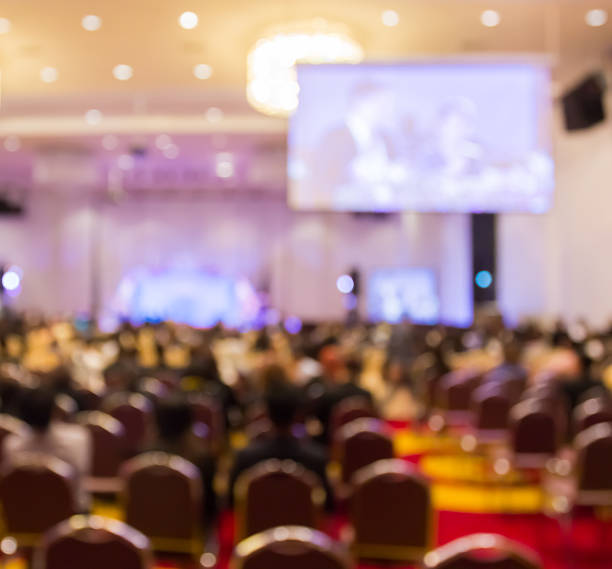 istock Blur  row of  people sitting  in auditorium with screen 538796200