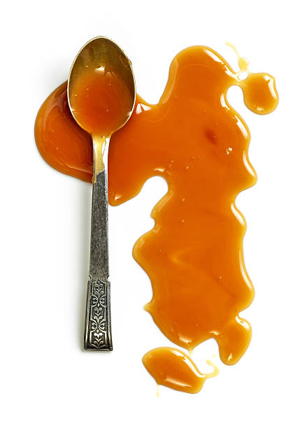 sauce caramel sur fond blanc - caramel sauces sweet sauce pouring photos et images de collection