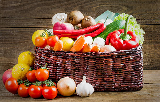 istock Wicker basket with fruits and vegetables on wooden table 538796972