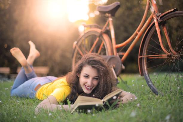 istock Happy woman reading in park 538798980
