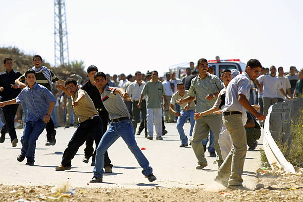 Second Intifada First Anniversary, Ramallah, October, 2001 Ramallah, Palestine - October 2, 2001: Young Palestinians throw stones at Israeli security forces during clashes marking the first anniversary of the Second Intifada. The Second Intifada was triggered by Ariel Sharon visiting the Temple Mount in Jerusalem's Old City. west bank stock pictures, royalty-free photos & images