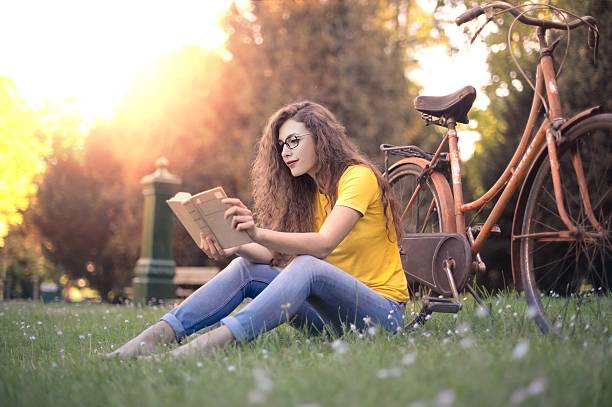 istock Young woman reading in a park 538799772