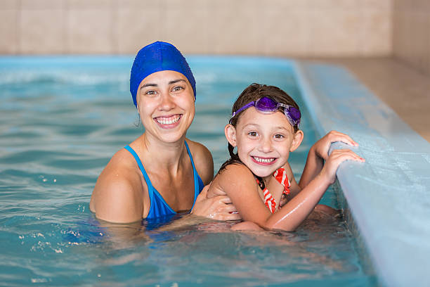 istock Swimming instructor smiling with a young girl in the pool 538800028