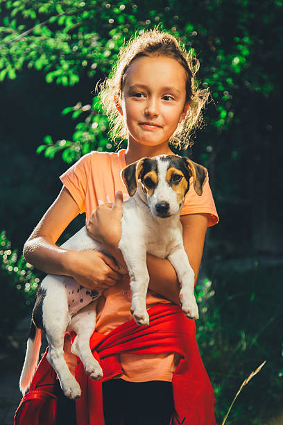 istock girl holding a dog smiling and looking at camera 538800520