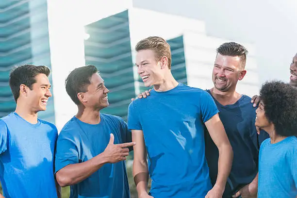 Photo of Multi-ethnic fathers and sons wearing blue shirts