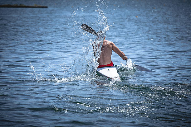 musculaire jeune homme en kayak de vitesse entraînement sur encore de l " eau. - skiff photos et images de collection