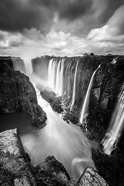 Long exposure of Victoria Falls from Zambia Site This stunning picture of the Victoria Falls has been taken from the Zambia site (Mosi-oa-Tunya Nationalpark). The Zambezi river is a natural border between Zimbabwe and Zambia.  landscape fog africa beauty in nature stock pictures, royalty-free photos & images