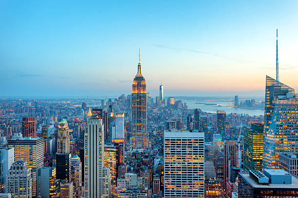 Manhattan panorama with its skyscrapers illuminated at dusk, New York illuminated skyscrapers in Manhattan at evening with Empire State Building and Freedom Tower - the new World Trade Center, New York City lower manhattan stock pictures, royalty-free photos & images
