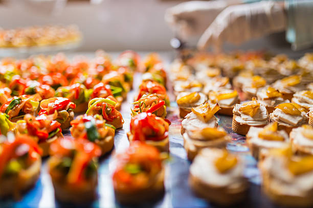 Closeup of a plate with canapes Closeup of a tray with rows of colored and delicious canapes. Chef arranging them in the background. restaurant food canapes appetizers stock pictures, royalty-free photos & images
