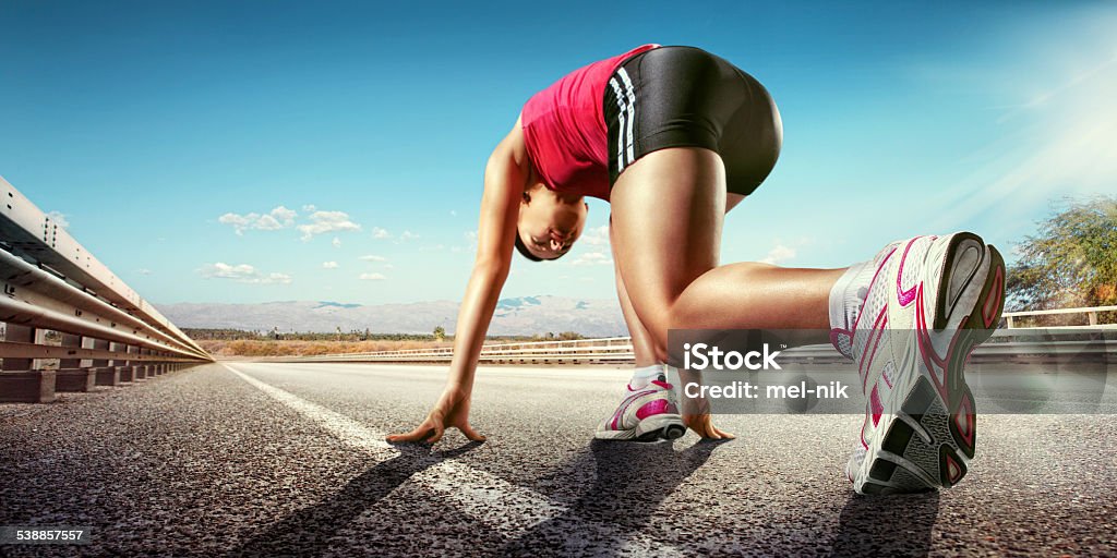 Sport. Runner low angle view of female runner running down road wearing trainers Running Stock Photo