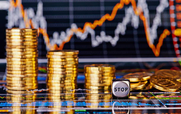 istock Downtrend golden coins stacks, dices cube with the word STOP 538857989