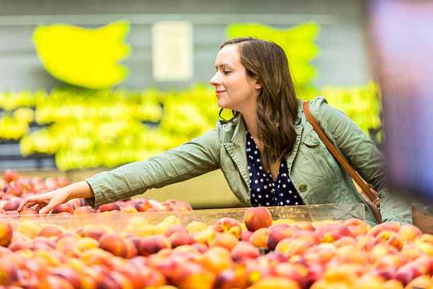 istock Beautiful brunette shopper picking out fruit 538863972