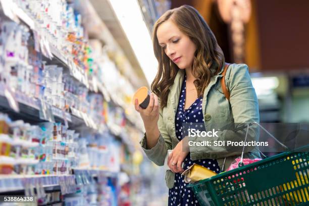 Woman Reading Food Labels At Grocery Store Stock Photo - Download Image Now - Supermarket, Shopping, Groceries