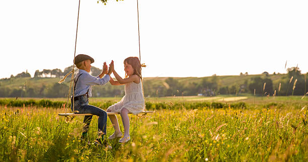istock Friends playing clapping game on swing over field 538867558