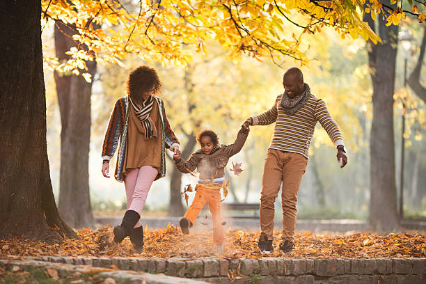 adorable famille afro-américaine à travers feuilles dans la nature. - child little girls smiling autumn photos et images de collection