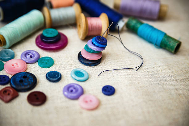 Sewing buttons and spools of threads on canvas. stock photo