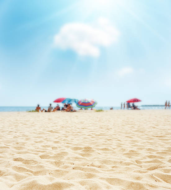 sand on beach closeup and sun in blue  sky sand on beach closeup and sun in blue  sky. soft focus on bottom of picture beach sand stock pictures, royalty-free photos & images