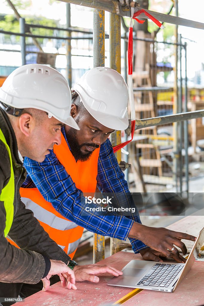 Construction Working At Computer Construction Workers Using Laptop Computer Among Scaffolding Stock ...