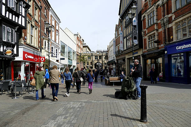 High street, Lincoln. Lincoln, Lincolnshire, UK. May 01, 2016.  Sunday morning with crowds of shoppers and a street busker on the High street, with the historic "Stonebow" in the distance of the historic town.  high street stock pictures, royalty-free photos & images