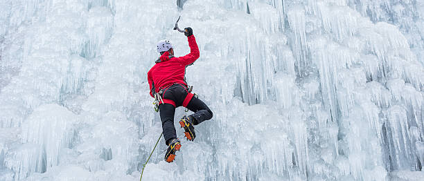 escalador de hielo congelado sobre una cascada - ice climbing fotografías e imágenes de stock