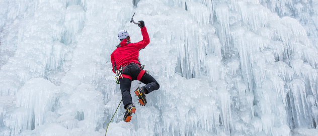 Ice climber ascending a frozen waterfall.