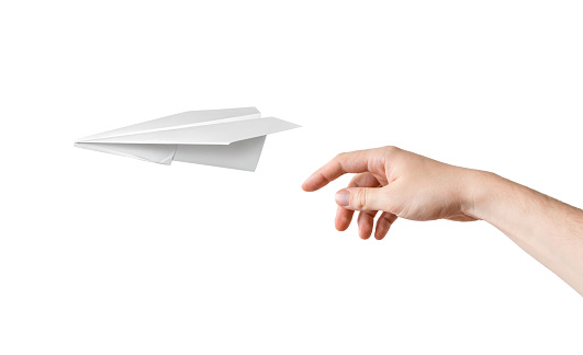 Hand is throwing origami paper airplane. Isolated on white background.