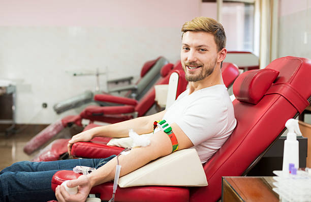 Man giving blood donation Smiling Man Blood Donor Making Donation In Hospital blood plasma stock pictures, royalty-free photos & images