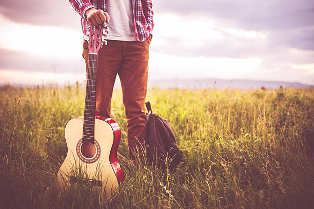 Music in nature Photo of young man in nature with guitar Slective Focus stock pictures, royalty-free photos & images