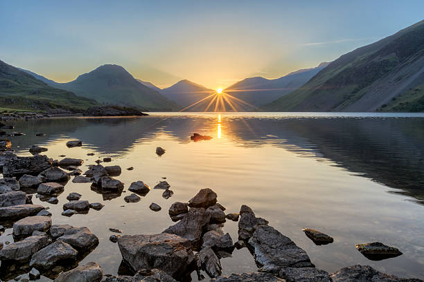 alba dorata sul lago wastwater con rocce e montagne. - dawn lake sky sunrise foto e immagini stock