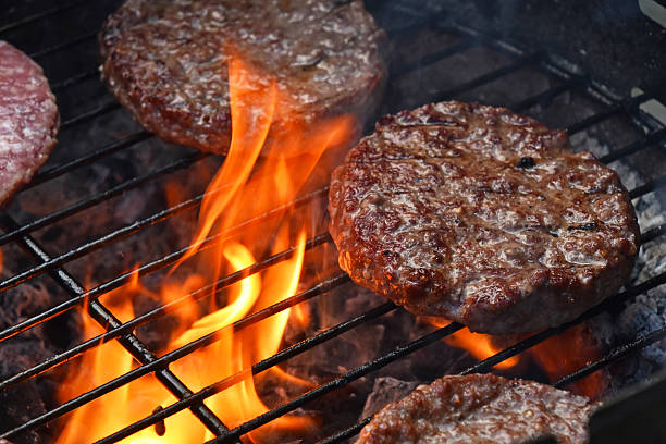 mięso burgerów w hamburger grillowane na działanie płomienia grill - broiling zdjęcia i obrazy z banku zdjęć