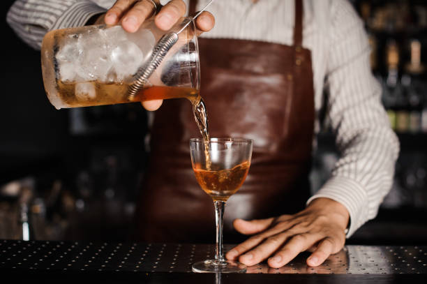istock barman pouring alcoholic cocktail in glass 538884654