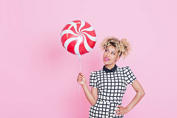 istock Afro American young woman holding candy balloon 538885072