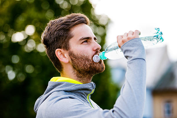 istock Young hipster runner in town with water bottle, drinking 538888154