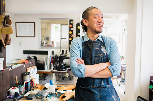 Portrait of a craftsman wearing an apron looking away from the camera. Kyoto, Japan. May 2016