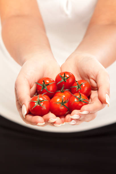 istock Young woman holding cherry tomatos 538888306