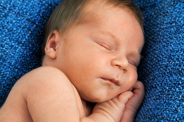 istock One week old baby on white blanket and female hand 538889524