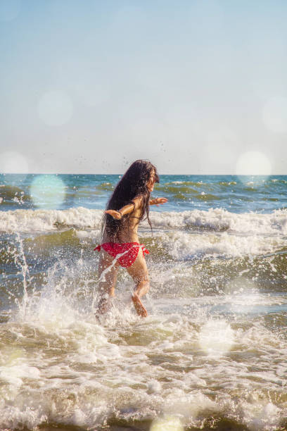 istock girl playing in sea 538889712