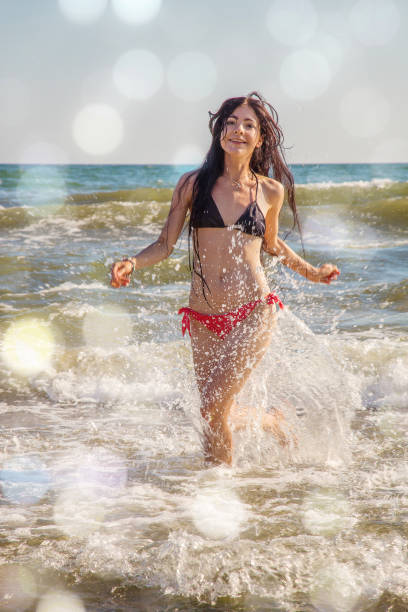 istock girl running in sea surf 538889764