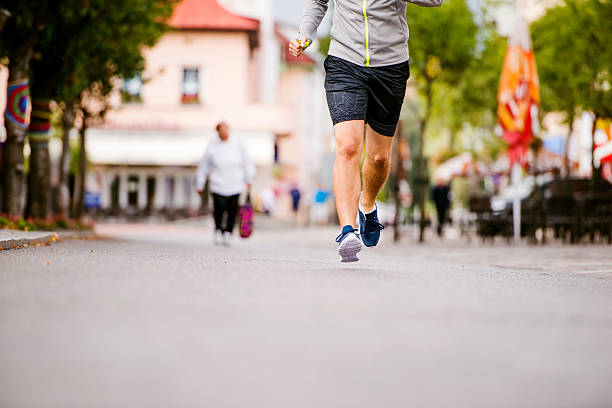 istock Unrecognizable young man running in town, main street 538891080