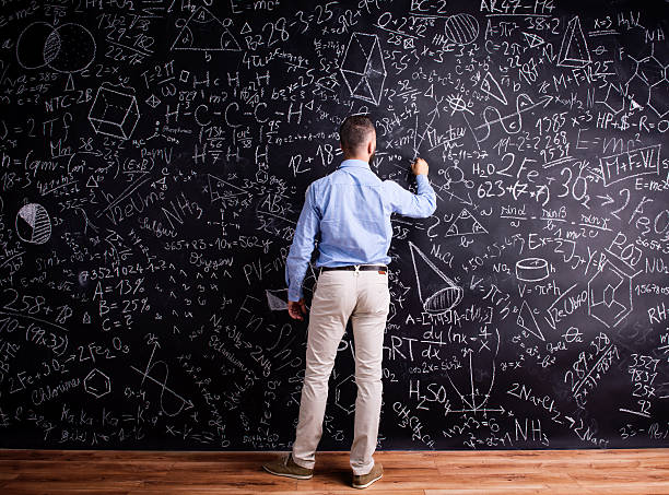 istock Man writing on big blackboard with mathematical symbols 538893100